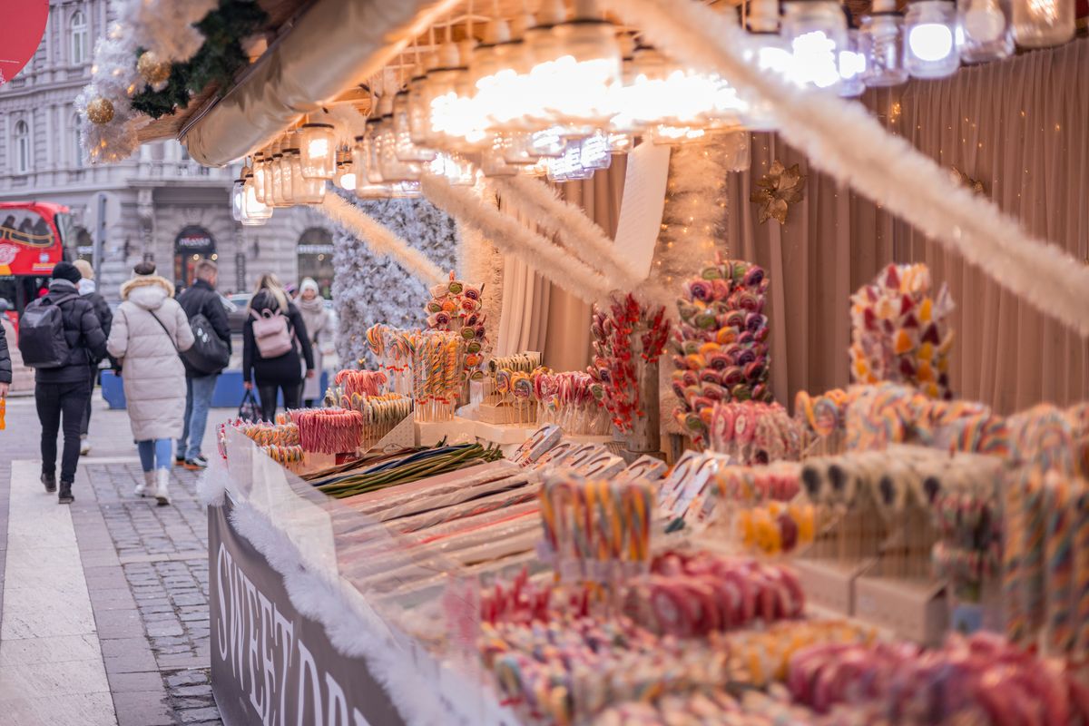 Süßwarenstand auf einem Budapester Markt mit bunten Lutschern und Lichterketten